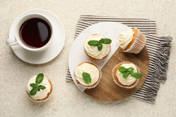 Delicious carrot cupcakes with mint and coffee on light textured table, flat lay