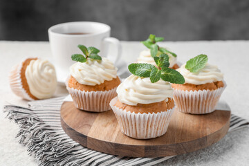 Delicious carrot cupcakes with mint on light textured table, closeup