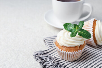 Delicious carrot cupcakes with mint on light textured table, closeup. Space for text