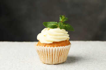 Delicious carrot cupcake with mint on light textured table, closeup