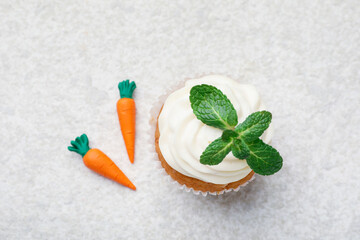 Delicious carrot cupcake with mint on light textured table, flat lay