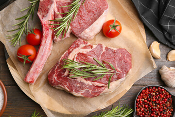 Pieces of raw beef, products and spices on wooden table, flat lay