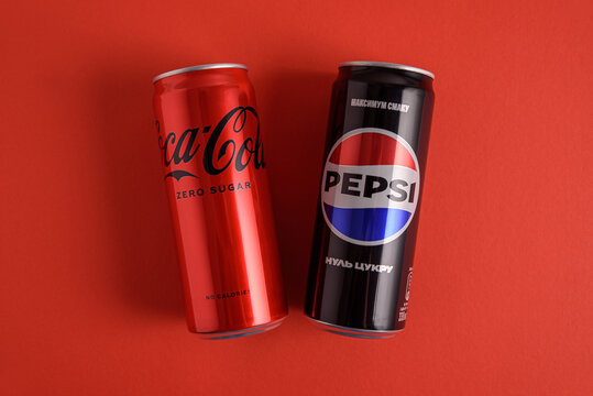 Lviv, Ukraine - March 25, 2025: Iron cans of drink Coca Cola and Pepsi zero sugar on red background. Top view