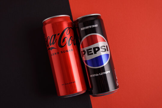 Lviv, Ukraine - March 25, 2025: Iron cans of drink Coca Cola and Pepsi zero sugar on red background. Top view