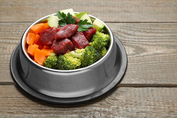 Fresh natural pet food in feeding bowl on wooden table, closeup