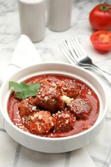 Delicious meatballs with tomato sauce, parmesan cheese and parsley served on white marble table, closeup