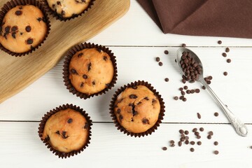 Delicious muffin with chocolate chips on white wooden table, flat lay