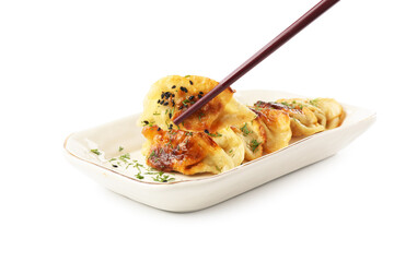 Taking tasty fried gyoza (dumpling) with chopsticks isolated on white
