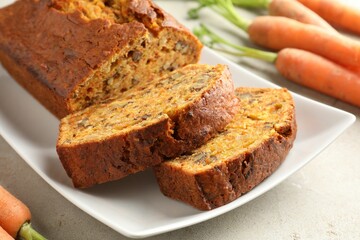 Homemade carrot cake with nuts and vegetables on light grey table, closeup