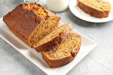Cut homemade carrot cake with nuts on grey table, closeup