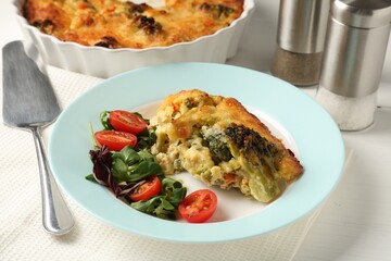 Tasty vegetable casserole and salad on white wooden table, closeup