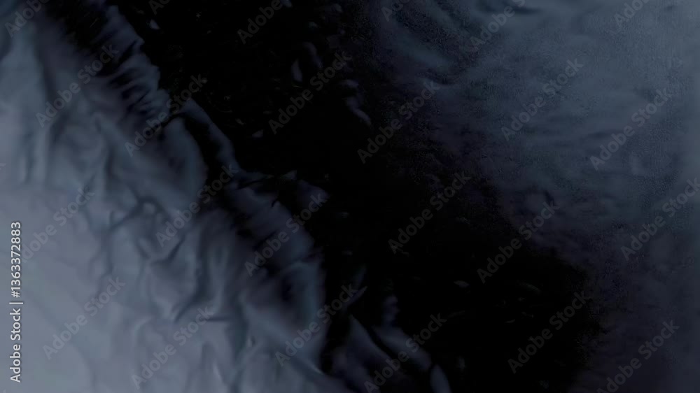 Poster abstract video still with a vertical camera angle showing flowing dark blue and black textures, crea