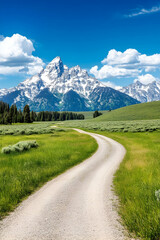 Obraz premium Winding dirt road leads to snow-capped mountains under a vibrant blue sky