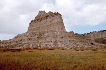 Golden prairie grass beneath towering sandstone cliffs at Scotts Bluff National Monument