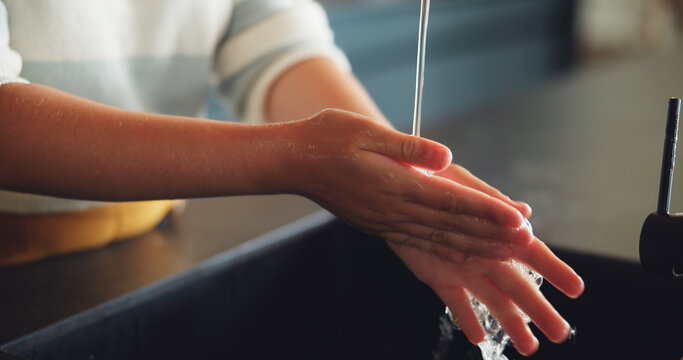 Person, hands and washing with water or tap for cleaning, rinse or bacteria and germ removal at home. Closeup, liquid and cleaner with faucet for skincare, anti bacterial or disinfection at house