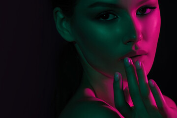 Young caucasian female in neon light with hand on face