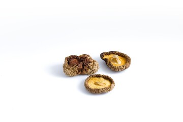 A refined arrangement of dried shiitake mushrooms on a white surface, showcasing intricate textures and rich flavor.