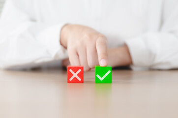 Decision-Making Concept. A person chooses between red X and green checkmark blocks, accept and rejected, true and false, yes or no, evaluation, vote, and correct versus incorrect choices. cross mark,