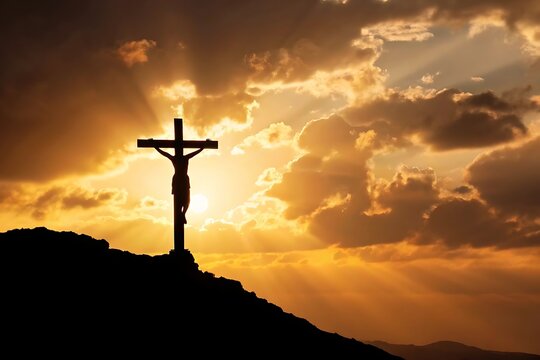 Naklejki A powerful silhouette of Jesus Christ crucified on a cross at sunset, bathed in golden light and dramatic clouds, signifying sacrifice and hope.