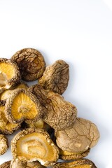 Dried shiitake mushrooms on a white backdrop reveal their detailed, rugged texture and deep organic hues.