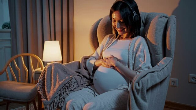 Pregnant woman listening music and feeling baby kick
