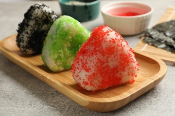 Tasty tobiko onigiri (Japanese rice balls) served on grey table, closeup