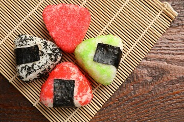 Tasty tobiko onigiri (Japanese rice balls) served on wooden table, top view