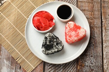 Tasty tobiko onigiri (Japanese rice balls) served on wooden table, top view