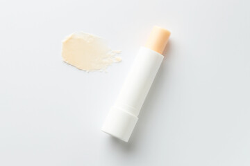 Stick of lip balm and sample on white background, top view