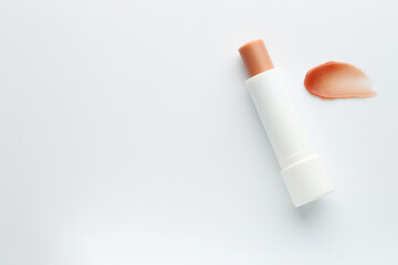Stick of lip balm and sample on white background, top view. Space for text