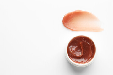 Jar and sample of lip balm on white background, top view. Space for text