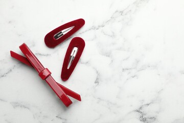 Beautiful hair clips on white marble table, flat lay. Space for text