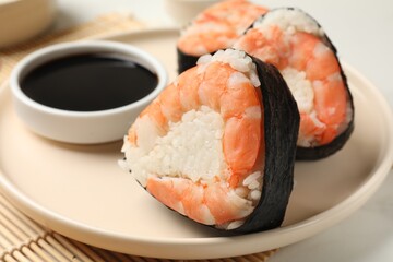 Tasty onigiri (Japanese rice balls) with shrimps and soy sauce on table, closeup