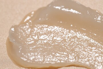 Moisturizing lip balm on beige background, closeup