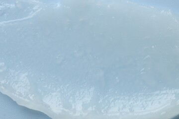 Moisturizing lip balm on light blue background, top view