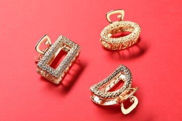 Beautiful hair clips on red background, above view