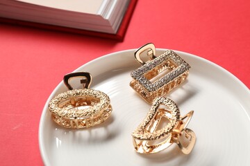 Beautiful hair clips on red background, closeup