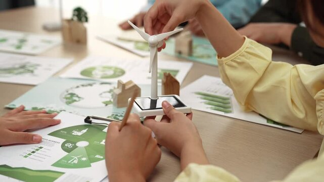 Business team focus windmill model, represented using clean energy. Coworker analyze green power graph choosing way to decrease carbon. Wooden block symbolized ecology house put on table. Delineation.