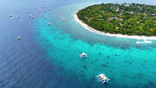Balicasag Island Panglao Bohol. Panoramic drone 4K aerial drone video footage view of lonely round island in Philippines with many traditional Philippines boats
