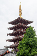  Senso-ji pagoda, a striking five story structure, exemplifies ancient wood architecture. Its towering presence is framed by lush greenery reflecting centuries of history.