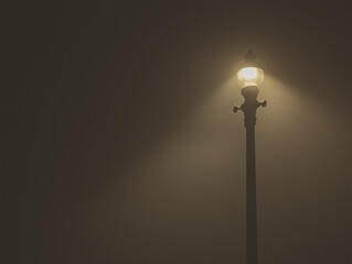 Dense fog wrapping around a streetlight at night