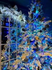 Captivating Christmas tree adorned in a frosty winter wonderland theme, featuring snow-dusted...