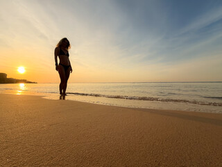 Fototapeta premium Silhouette of young woman relaxing at the beach