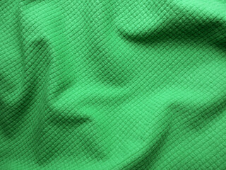 Green microfleece fabric texture. Close up of wrinkled fleece fabric