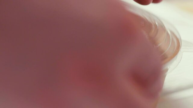 Closeup of man paking up a fresh healthy salad to a zero waste container to go. Food delivery, healthy food concept.