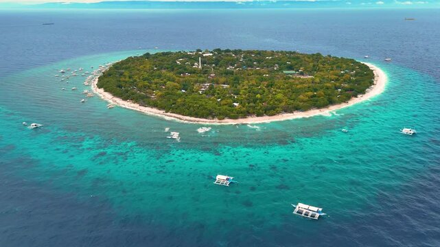 Balicasag Island Panglao Bohol. Panoramic drone 4K aerial drone video footage view of lonely round island in Philippines with many traditional Philippines boats