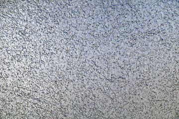 White wall surface dotted with black dots