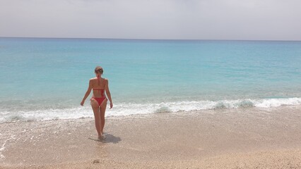 A Woman in a Red Bikini Walking into the Turquoise Waters of the Ocean