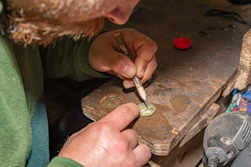 homme grattant une pièce trouvée avec un détecteur de métaux dans la terre