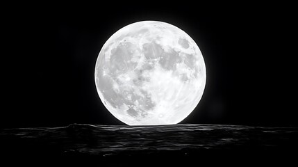 A luminous full moon ascending above a shadowed terrain